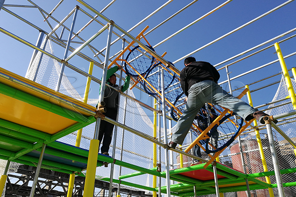 workers are installing an indoor adventure zone